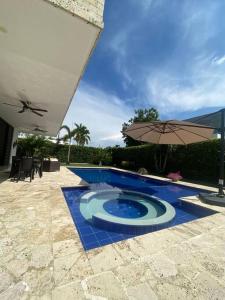 a swimming pool with an umbrella next to a patio at Condominio Flandes - Girardot in Guayacana