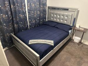 una camera da letto con letto con lenzuola blu e tenda di Jorge Salcido a Long Beach