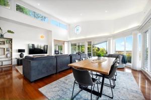 a living room with a wooden table and chairs at Pacific Vista in Coffs Harbour