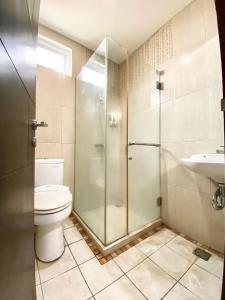 a bathroom with a shower and a toilet and a sink at Behomy Corner Eight Lippo Karawaci in Tangerang +18 photos
