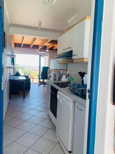 una cucina con piano cottura e lavastoviglie di At Sea, Melkbosstrand a Melkbosstrand