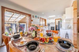 a table with food and drinks on it in a kitchen at 4 Gilchrist Rd - pet friendly, air con, Wi-Fi in Salamander Bay