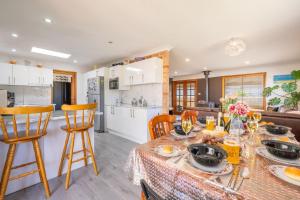 a kitchen and living room with a table and chairs at 4 Gilchrist Rd - pet friendly, air con, Wi-Fi in Salamander Bay +20 photos