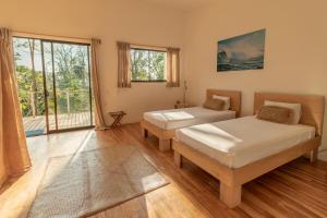 a bedroom with two beds and a large window at La Sana Surf Hotel, Playa Carmen in Santa Teresa Beach +151 photos