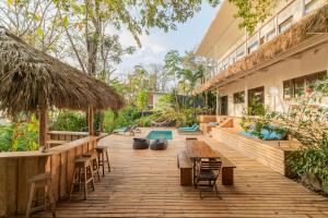 Un patio al aire libre con mesas y sillas y una piscina. en La Sana Surf Hotel, New design, Few mn drive to the beach, en Santa Teresa Beach