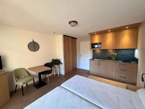 a bedroom with a bed and a table and a kitchen at Résidence La Rochetaillée in Brides-les-Bains