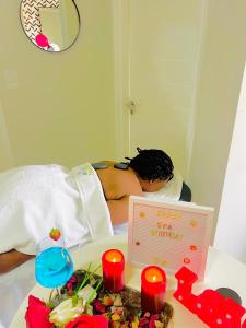 a woman laying in a hospital bed with a plate of food at Taina Apartment @ Green Creek in Pretoria