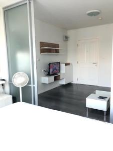a white living room with a table and a tv at Dcondo campus resort Bangsaen in Ban Rong Khoei