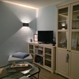 a living room with a tv and a table at Seeschloss 30 in Dahme