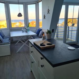 a kitchen with a counter and a table and some windows at Seeschloss 30 in Dahme
