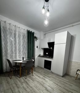 a living room with a table and a kitchen at Apartament MaGiFa Mamaia Nord in Năvodari