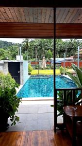 Una vista de una piscina desde una casa. en Cetli house farm &stay, en Ban Khlong Son