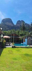 un complejo con una piscina con montañas de fondo en Cetli house farm &stay, en Ban Khlong Son