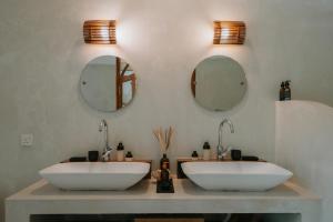 two sinks in a bathroom with two mirrors at The Oasis Villa in Ahangama +12 photos