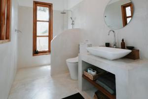 a white bathroom with a sink and a toilet at The Oasis Villa in Ahangama