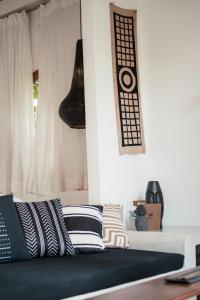 a bedroom with a bed with black and white pillows at The Oasis Villa in Ahangama