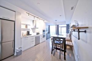 a kitchen with white cabinets and a table and chairs at The York I in Toronto