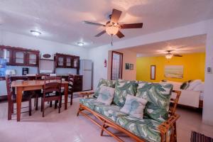 Una sala de estar con un sofá y un comedor. en Seven Seas Resort Adults Only, en San Pedro