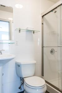 a white bathroom with a toilet and a shower at The Park Ave North in New York