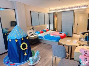 a bedroom with a bed and a room with a table at Echarm Hotel Guiyang Municipal Government Lin Cheng Xi Road Metro Station in Guiyang