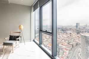 an empty room with a chair and large windows at Beautiful Deluxe 1bd Condo Poolgymparking! #373 in Istanbul