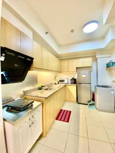 a kitchen with wooden cabinets and a stainless steel refrigerator at Infina Towers in Manila