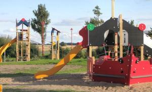 einen Spielplatz mit Rutsche in einem Park in der Unterkunft Ferienwohnung Bakenberg auf Rügen (So) in Dranske