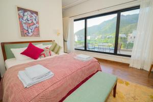 a bedroom with a bed and a large window at UNA Services - Margalla Retreat in Islamabad +54 photos
