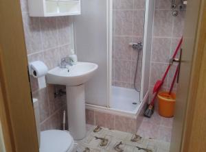 a bathroom with a sink and a toilet and a shower at Bright and Modern: Fully Furnished Krk Apartments with Private Parking in Vrh