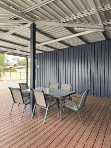 a patio with a table and chairs on a deck at Red Emu Motel in Perenjori