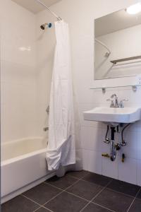 La salle de bains est pourvue d'un lavabo, d'une baignoire et d'un miroir. dans l'établissement The Park Ave North, à New York