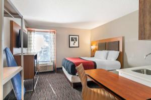 a hotel room with a bed and a sink at MainStay Suites Springfield IL in Springfield