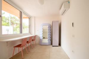 a room with a table and chairs and a window at Spacebility Beach - self check-in in Quartu SantʼElena