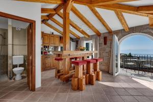 a kitchen with a counter with red stools at Villa Sanja - Makarska Exklusiv in Makarska