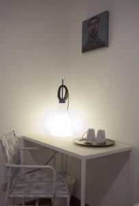 un escritorio blanco con una silla y una foto en la pared en B&B Gallery, en Bérgamo