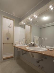 baño con 2 lavabos y espejo grande en B&B Gallery, en Bérgamo