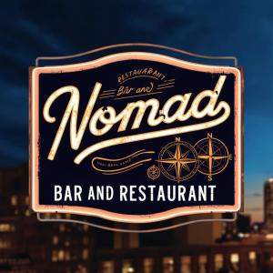 桔井Nomad Guesthouse的建筑前的酒吧和餐厅标志