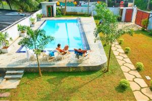 two people sitting in chairs in a swimming pool at Wake N Flow, Weligama in Weligama +38 photos