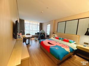 a bedroom with a large bed and a living room at Echarm Hotel Guiyang Municipal Government Lin Cheng Xi Road Metro Station in Guiyang