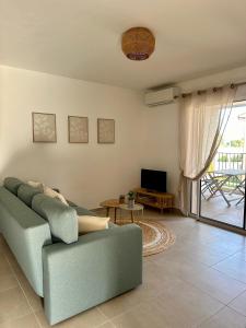 a living room with a couch and a television at Appartement HARMONIE in Saint-Florent