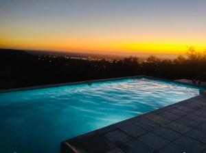 a swimming pool with a sunset in the background at Mirador Merlo in Merlo