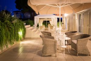 a patio with chairs and tables and an umbrella at Casa di Terra in Gythio