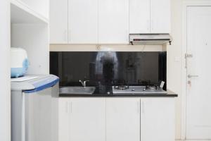 当格浪Fully Furnished with Comfortable Design 1BR Apartment Silkwood Residences By Travelio的带水槽和微波炉的白色厨房