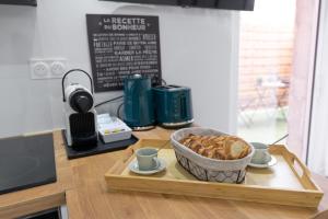 a table with a bowl of food on a cutting board at Le Petit Enclos - Appt climatisé parking privé in Vaulx-en-Velin