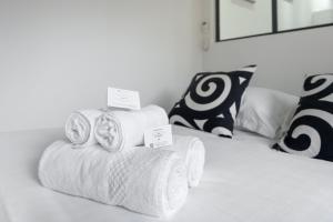 a pile of towels sitting on top of a bed at Le Petit Enclos - Appt climatisé parking privé in Vaulx-en-Velin