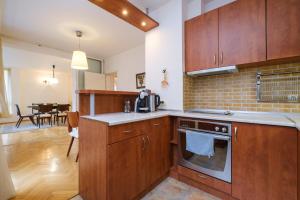 a kitchen with wooden cabinets and a dining room at The Hill House Free Parking in Plovdiv