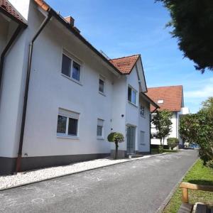una casa bianca con un albero in strada di Moderne und Gemütliche Stadtnahe Wohnung a Hassfurt