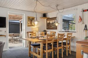 a dining room with a wooden table and chairs at Feriehus 1086 in Ulfborg +25 photos