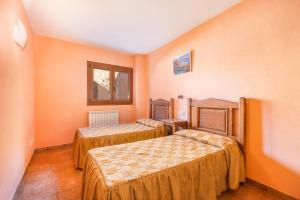 two beds in a room with orange walls at El Paller in Durro
