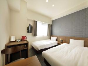 Postel nebo postele na pokoji v ubytování Smart Place Inn Kyoto Nijojo-mae Station